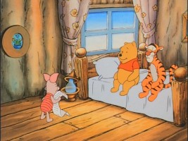 Piglet shares his own writing with an attentive Pooh and Tigger.