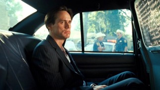 Beat but not beaten, Steven Russell (Jim Carrey) plans his next move from the back seat of a police car.
