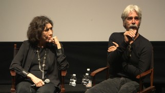 Sam Elliott gives his bicep a feel as he answers an audience member question at a Q & A next to Lily Tomlin.
