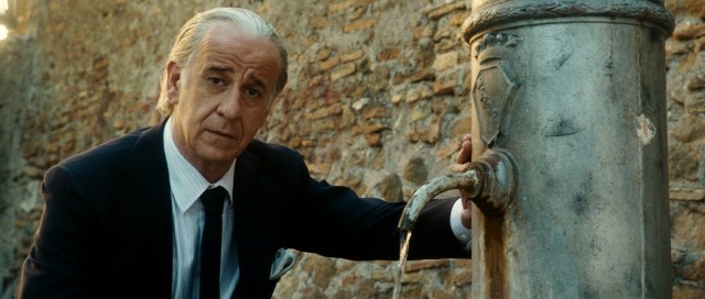 Another night of partying behind him, Jep Gambardella (Toni Servillo) uses a fountain to get water.