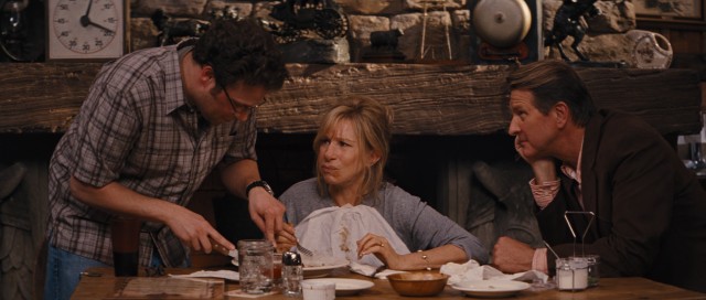 Andy (Seth Rogen) helps his mother (Barbra Streisand) by cutting the 72-ounce steak she tries to eat in an hour, while an admiring cowboy (Brett Cullen) looks on.