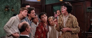 Rose Hovick (Rosalind Russell) offers Mr. Goldstone eggrolls and a song with the accompaniment of Dainty June and her farm boys.