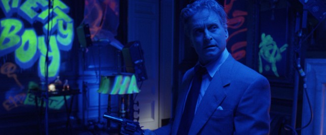 His home vandalized by fluorescent graffiti and blaring Jefferson Airplane, Nicholas Van Orton (Michael Douglas) reaches for his gun.