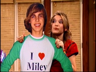 Lilly (Emily Osment) votes that Miley give Jake Ryan (Cody Linley), the apologetic movie star of this cardboard standee, another chance in "Achy Jakey Heart."