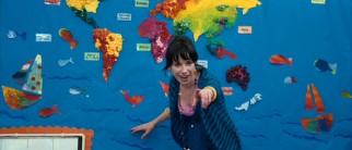 Standing in front of a colorful world map, elementary school teacher Poppy Cross (Sally Hawkins) looks pleased by her student's answer.