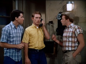 With support from Potsie (Anson Williams, left) and Ralph Malph (Donny Most, right), Richie Cunningham (Ron Howard, center) puts on an adult voice to inquire about vacation property.