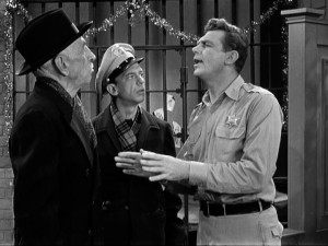 Sheriff Andy Taylor (Andy Griffith) is tested by miserly storeowner Ben Weaver (Will Wright), while Barney Fife (Don Knotts) looks on.