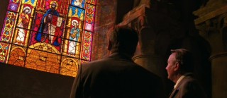 Indiana Jones and old colleague Dr. Marcus Brody (Denholm Elliott) observe the Venetian stained glass windows that are meant to lead them to the missing Dr. Jones.