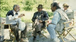 Sean Connery, Harrison Ford, and Steven Spielberg have a chat in the shade in footage seen in The Last Crusade's introduction.