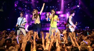 Fan hands go a-reaching as the Jonas Brothers are joined by Demi Lovato for a rendition of the "Camp Rock" song "This is Me."