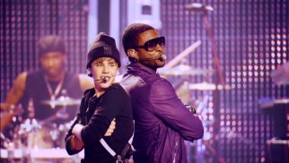 Their awkward first meeting long behind them, Justin Bieber and Usher finish their song "Somebody to Love" back-to-back to see who's taller. (Usher is.)