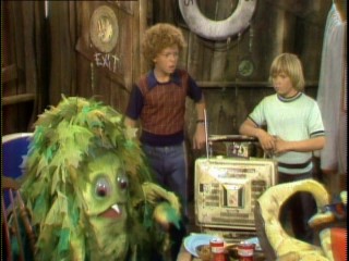 Sigmund (Billy Barty), Johnny (Johnny Whitaker), and Scott (Scott Kolden) are surprised to find sea monster patriarch Big Daddy enjoying their clubhouse television.