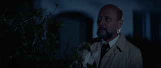 Dr. Sam Loomis (Donald Pleasence) waits in the bushes near Michael Myers' old home.