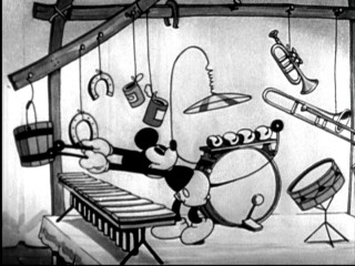 Mickey Mouse uses both hands and his tail to keep up with the Jonas Brothers' "Play My Music."