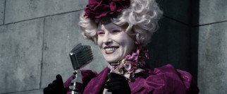 The interestingly-fashioned Effie Trinket (Elizabeth Banks) cheerily chooses the youths who will represent District 12 in the deadly 74th Annual Hunger Games.