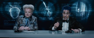 Claudius Templesmith (Toby Jones) and Caesar Flickerman (Stanley Tucci) provide Hunger Games color commentary in glitzy attire.