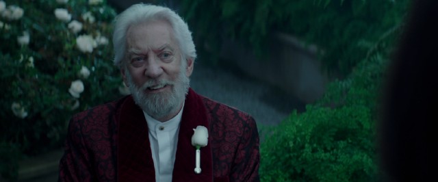 President Snow (Donald Sutherland) is all smiles in his greenhouse, having expected a visit from Katniss.