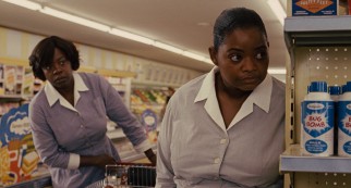 Aibileen (Viola Davis) and Minny (Octavia Spencer) are shocked to spot someone reading their book at the supermarket deli counter.