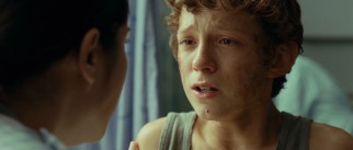 Upset twelve-year-old survivor Lucas (Tom Holland) gets an update from an English-speaking nurse.