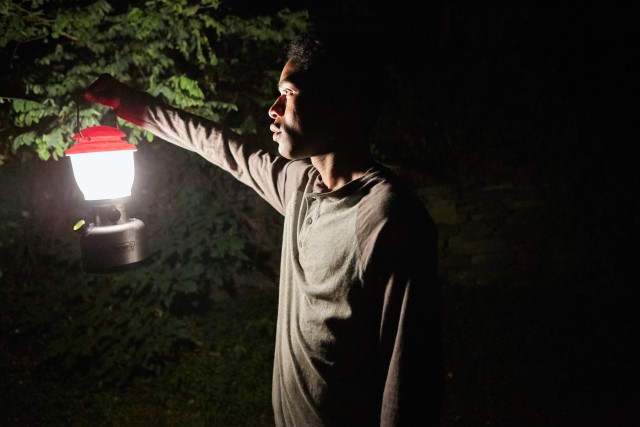 Seventeen-year-old Travis (Kevin Harrison Jr.) goes searching in the dark woods with a torch in hand.