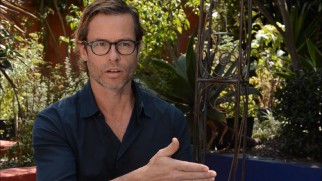 Guy Pearce dons glasses for his behind the scenes featurette interview.