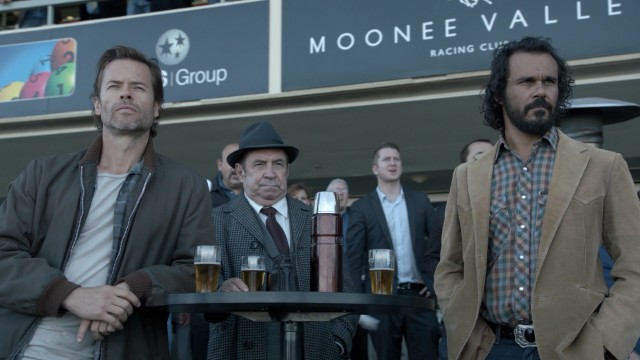When he's not on the search for answers, Jack Irish (Guy Pearce) can be found at the racetrack with his mates Harry Strang (Roy Billing) and Cam Delray (Aaron Pedersen).