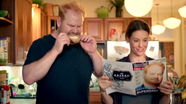 While Jim Gaffigan bites into a bagel, his wife Jeannie (Ashley Williams) reads about the man Time Out New York calls "Superdad!"