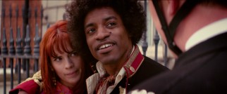 British police officers confront Kathy Echingham (Hayley Atwell) and her boyfriend Jimi Hendrix (Andr Benjamin) about his choice in military coats.
