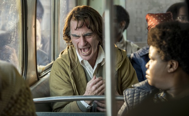 Arthur Fleck (Joaquin Phoenix) upsets fellow Gotham City bus riders with his medical condition of uncontrollable, inexplicable laughter.