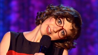 Aided by red glasses, Kristen Schaal does an impression of Sally Jesse Raphael.