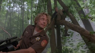 As Sheriff Riley, John Schneider uses his favorite, and only, expression and looks intently in the misty woods.