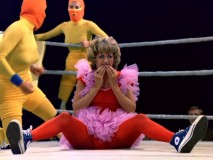 Laverne checks if all her teeth are in place as her opponents confer in the background in "Tag Team Wrestling."