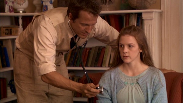Reverend Cotton Marcus (Patrick Fabian) examines Nell Sweetzer (Ashley Bell) to determine if she requires exorcism. As the title suggests, she does.