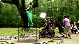 Adam Shankman (in lavender) walks with the light and camera crew circling Miley Cyrus for her music video.