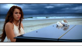 As in the film, Miley Cyrus pouts and fakes piano playing in the "When I Look at You" music video.