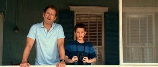 Father (Greg Kinnear) and son (Bobby Coleman) check out Ronnie's beach activities.