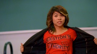 Stella Yamada (Hayley Kiyoko) interrupts the gymnasium's dedication ceremony to live up to her T-shirt and "Question? Authority."