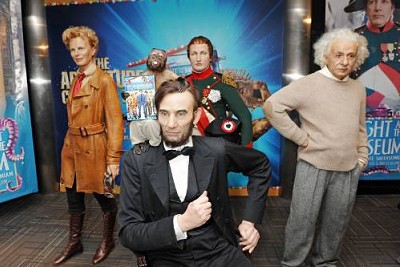 Crystal the capuchin monkey holds up one of the ceremonial first DVD copies of "Night at the Museum 2" by the newly-unveiled wax statues of Abraham Lincoln, Amelia Earhart, Napoleon Bonaparte, and Albert Einstein.