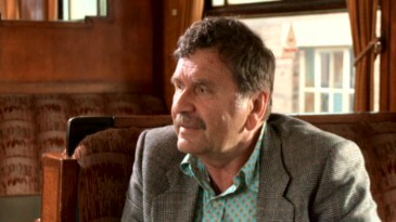 Film professors and historians Bruce Babington and (unseen across from him) Peter Evans pay tribute to the film by discussing it on a day train to nowhere.