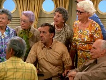 Oscar and the rest of the passengers on the senior cruise stare incredulously as Felix tries to rouse them into a game of Simon Says.