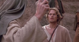 Jesus of Nazareth (Willem Dafoe) stands up to the angry mob about to stone his prostitute friend.