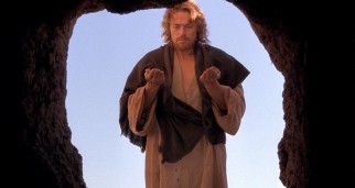 Standing outside Lazarus' tomb, Jesus (Willem Dafoe) resurrects the recently deceased man.