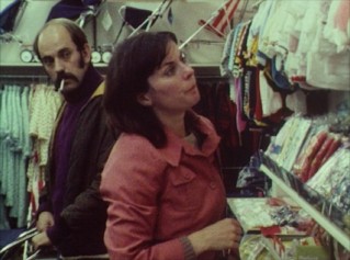 A couple (Richard Ireson and Celia Quicke) shops for baby clothes in Mike Leigh's 1975 short "The Birth of the Goalie of the 2001 F.A. Cup Final."