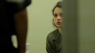 Anna's (Felicity Jones) airport detainment by immigration officers is artistically shot from a distance from a partially obscured angle.