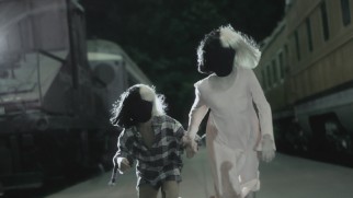 Two Sia-esque children reunite in the lyric video for Sia's end credits song "Never Give Up."