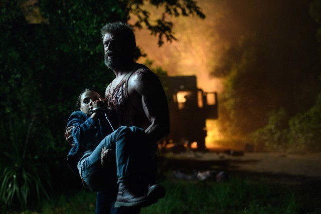 A bloodied Wolverine (Hugh Jackman) clutches to his fierce daughter Laura (Dafne Keen) in "Logan."