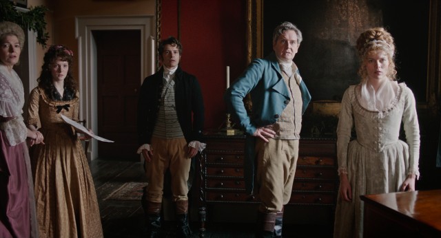 Posed as if in portrait, Frederica (Morfydd Clark) and the DeCourcy family are surprised by Lady Susan's return.