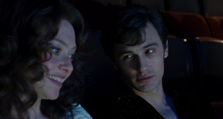 A young Hugh Hefner (James Franco) invites Linda Lovelace (Amanda Seyfried) to sit beside him during the private "Deep Throat" screening he hosts.