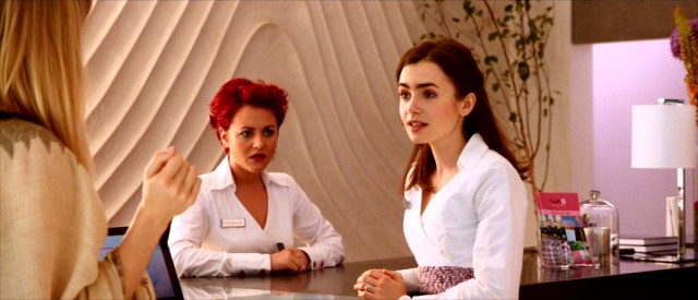 Rosie (Lily Collins) works toward her hotelier dreams with her magenta haired pharmacist turned friend Ruby (Jaime Winstone) by her side.