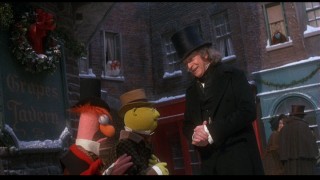 Having had a change of heart, Scrooge decides to donate to neighborhood collectors (played by Bunsen Honeydew and his unintelligible assistant Beeker).